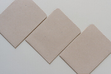 three cardboard objects (envelopes) with stripe pattern