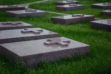 Gray Marble Tombstones With Crosses On A Green Lawn In A Cemetery. Memory And Sorrow.