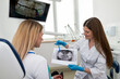 © Tania - The dentist shows the x-ray image to the patient. People, medicine, dentistry, technology and healthcare concept.