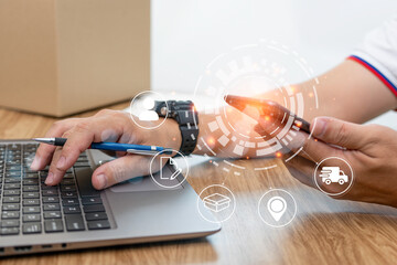 Delivery process on virtual screen concept : Close up hand a man tying on laptop check transport delivery parcel box to customer in shopping online on wood table and parcel box in blur background