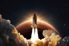 Shuttle Rocket Successfully Takes Off Into Space On A Background Of The Red Planet Mars With The Sunrise. Spaceship With Clouds Of Smoke And Blast Liftoff Into Stellar Sky. Concept Of Space Travel