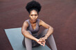 © etonastenka - African American woman in sportswear is resting in the stadium after running or training. Fitness woman exercising outdoors.