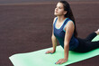 © etonastenka - Young Arab woman doing yoga outdoors in the stadium. Woman doing upside down dog pose.