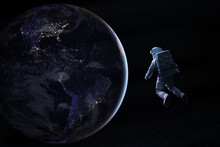 Astronaut In Deep Space Looks On Night Earth Planet. Elements Of This Image Furnished By NASA.