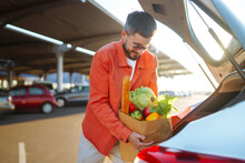 Shopping Time. Healthy Vegan Vegetarian Food In A Paper Bag In The Male Hands. Young Man With Shopping Bag Full Of Vegetables Near The Car. 