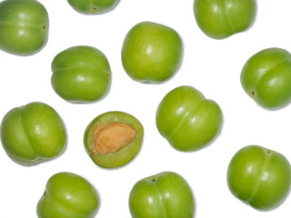 Green cherry plum on a white background. Fruit for making tkemali sauce. . Useful fruits. Sweet and sour fruit. Juicy cut green plum