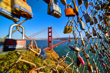 San Francisco Iconic Golden Gate Bridge Through Opening In Fence Covered In Locks