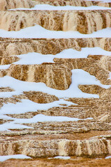 Snow covering terrace layers in detail at Yellowstone hot springs