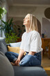 © baranq - Adult woman sitting on the couch with closed eyes. Mindfulness concept
