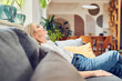 © baranq - Adult woman resting on a sofa sitting relaxed with eyes closed