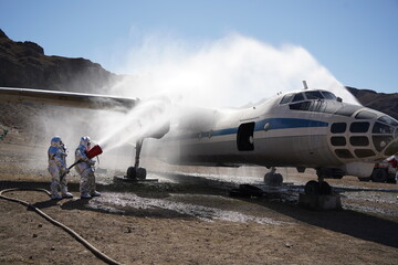 Almaty, Kazakhstan - 09.22.2021 : Rescuers in special protective suits extinguish the plane in training