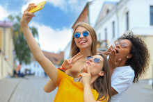 Three Cute Young Girls Friends Having Fun Together, Taking A Selfie At The City.