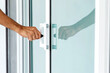 © ETAP - Close-up of man's hand opening a glass door with a key.