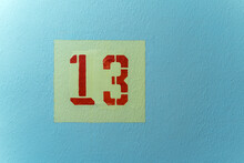 The Number 13 Red In A Yellow Square On A Blue Background