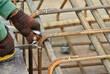 MALACCA, MALAYSIA -MARCH 30, 2016: Construction workers fabricating steel reinforcement bar at the construction site in Malacca, Malaysia. The reinforcement bar was ties together using tiny wire.  
