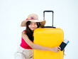 © tete_escape - Happy Asian woman in pink sleeveless shirt and beach hat holding passport, flight ticket and hug yellow suitcase isolated on white background. Young traveler ready with excited to summer trip.