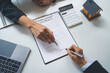 © crizzystudio - Signing of a contract between a real estate agent or home developer that presents a contract for the sale of a home to an advisor. Real estate contract signing concept