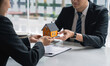 © crizzystudio - Real estate agent, Asian businessman handing model houses to customers, Real estate trading ideas, and bank loans for buying and selling houses and land.