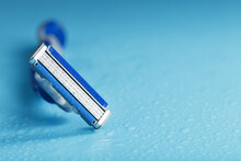 Razor Blades On A Blue Background With Drops Of Icy Water