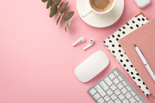 Business Concept. Top View Photo Of Workspace Keyboard Computer Mouse Stylish Notepads Pen Cup Of Coffee On Saucer Earbuds And Eucalyptus On Isolated Pastel Pink Background With Copyspace