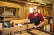 © bondvit - Portrait of a senior carpenter in uniform gluing wooden bars with hand pressures at the carpentry manufacturing
