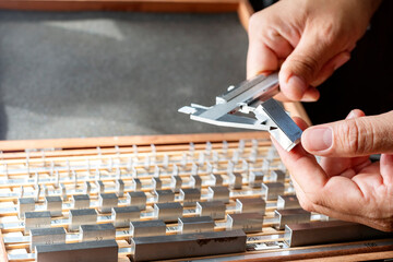 Wall Mural - The inspector is calibrating a vernier caliper micrometer with a gauge block. A small number of gauge blocks can be used to create accurate lengths within a wide range.