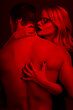 Blonde woman seducing young man body in red light