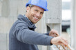 © auremar - happy man builder looking at camera while installing metal beams