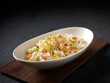 Yang Zhou Fried Rice served in a dish isolated on cutting board side view on dark background