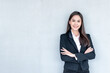 © Anatta_Tan - Portrait images of an Asian business woman, attractive and young,  Standing and smile with cement wall background, to people and business concept.