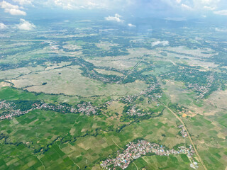 The aerial landscape shows a green view of the city. Streets, rice fields, and village houses.