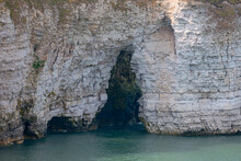 Close-up Of Layered White Chalk Cliffs Showing Wave Erosion In Arches And Caves Over The North Sea At Flamborough
