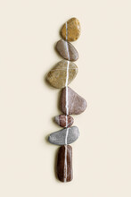 Top View Still Life With Close Up Sea Stones On Sand Background, Pebbles United By One Vertical Row. Row From Natural Stone Natural Tones. Minimal Style, Concept Of Calm, Peace, Meditation