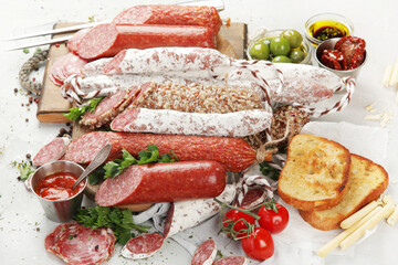 Wall Mural - Sausages salami assortment on light background.