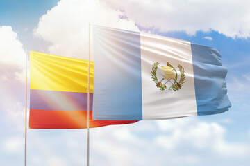 Sunny blue sky and flags of guatemala and colombia