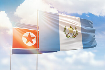 Sunny blue sky and flags of guatemala and north korea