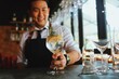 © Mallika - Handsome male bartender in apron preparing drink for customer at bar counter. Asian bartender man making some drink for guest of hotel.