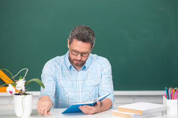 Portrait of confident caucasian male teacher in classroom. Middle aged man professor at high school. Teachers day.