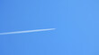 Smuga spalin zostaje za niebem za lecącym samolotem.
