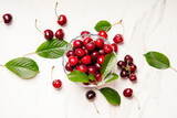 Cherry background. Sweet cherries with green leaves on the table. Top view.