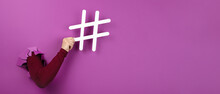 Hand Holding Hashtag Sign Over Pink Background, Social Media Concept, Panoramic Layout
