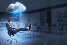 Businessman Pointing At Laptop While Relaxing In Swivel-chair In Blurry Office Interior With Abstract Hologram Raining Cloud And Mock Up Place For Your Advertisement. 