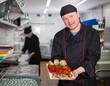 © JackF - Portrait of confident chef working in restaurant kitchen, showing right off stove dish
