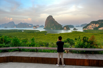 Sticker - male tourist taking pictures Panorama view of Samet Nangshe, Phang Nga, Thailand in the beautiful sky and clouds. Spectacular nature and stunning views of mountains and islands in the Andaman Sea.