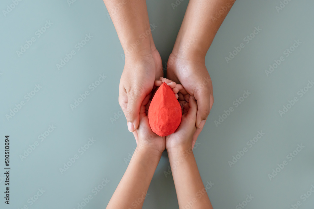 Blood donation or medical surgery concept. Human holding small piece of paper blood sign and a red heart shape. Give blood save lives.