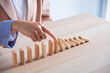 business woman hand stop wooden block tower stack crash or fall domino  ,financial business and risk management
