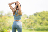 Fototapeta Las - Back view of sport woman warming up outdoors, Fitness woman doing stretch exercise stretching her arms