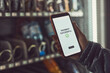 © Przemek Klos - Consumer paying for product at vending machine using contactless method of payment with mobile phone. Woman using payment app on smartphone to buy product