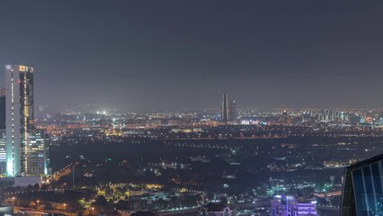 Wall Mural - Aerial view of houses in Deira and Dubai creek district with typical old and modern buildings night timelapse. Skyscrapers of downtown. Dubai, United Arab Emirates