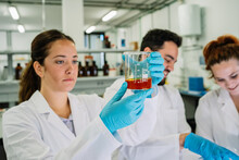 Serious Chemist Examining Liquid In Flask In Lab